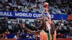 Pebasket Spanyol, Juancho Hernangomez (tengah) melepaskan shooting dibayangi dua pebasket Pantai Gading, Vafessa Fofana (kiri) dan Jean Philippe Dally pada laga Grup G Piala Dunia FIBA 2023 di Indonesia Arena, Senayan, Jakarta, Sabtu (26/08/2023). (Bola.com/Bagaskara Lazuardi)