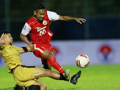 Gelandang Bhayangkara Solo FC, TM Ichsan (kiri) berebut bola dengan gelandang Persija Jakarta, Ramdani Lestaluhu dalam laga matchday ke-3 Grup B Piala Menpora 2021 di Stadion Kanjuruhan, Malang, Rabu (31/3/2021). (Bola.com/M Iqbal Ichsan)