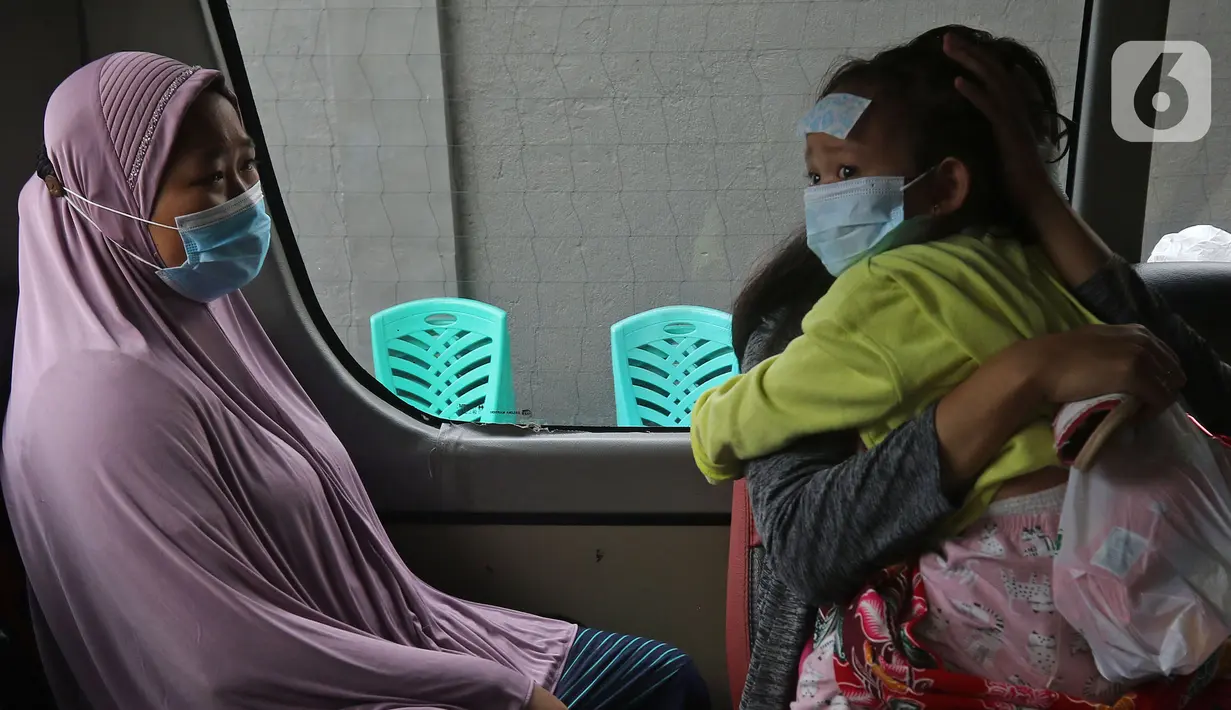 Warga berada di dalam mobil ambulans saat akan dibawa ke wisma atlet di Jalan As-Syafiiyah, Cipayung, Jakarta, Jumat (21/5/2021). Klaster Halal Bihalal di Cipayung bertambah 32 orang dari 51 orang menjadi 83 orang terpapar COVID-19 perhari ini. (Liputan6.com/Herman Zakharia)