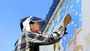 Seorang mahasiswa dari Universitas Seni Jilin melukis di tembok sebuah rumah di Desa Qingshui, Kota Changchun, China timur laut (18/6/2020). Para mahasiswa dan pengajar dari Universitas Seni Jilin menghiasi desa tersebut dengan mural. (Xinhua/Lin Hong)