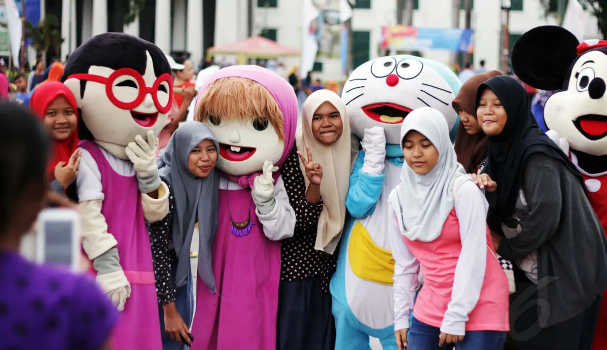 Kawasan Kota Tua Jakarta masih menjadi lokasi wisata favorit warga Jakarta, Jumat (26/12/2014). Sejumlah pengunjung berfoto bersama boneka tokoh film kartun di kawasan Kota Tua Jakarta. (Liputan6.com/Faizal Fanani)