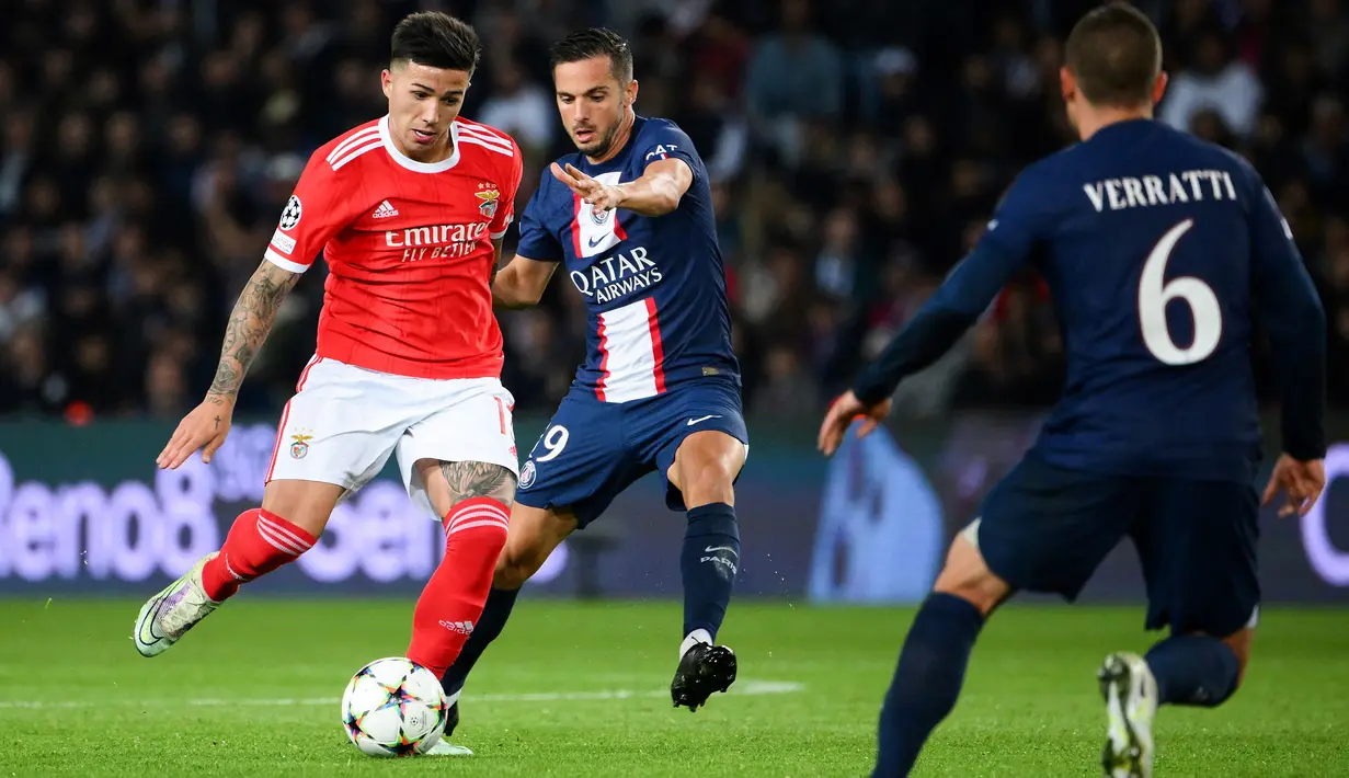 Aksi pemain Benfica, Enzo Fernandez (kiri) saat menghadapi PSG dalam laga Grup H Liga Champions 2022/2023 di Parc des Princes Stadium, Paris (11/10/2022). Gelandang tengah yang baru saja didapatkan Chelsea pada bursa transfer Januari 2023 ini menjadi pemain Argentina termahal sepanjang sejarah. The Blues harus merogoh kocek senilai 121 juta euro atau hampir setara Rp2 triliun untuk memboyongnya dari Benfica. (AFP/Anne-Christine Poujoulat)
