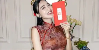 Wika Salim tampil anggun mengenakan slit dress cheongsam warna merah. Cheongsam tersebut memiliki kerah tinggi dan kancing shanghai. Dipadukan heels nude. [@wikasalim]