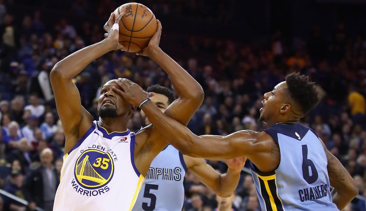 Pemain Warriors, Kevin Durant #35 mencoba memasukan bola saat diadang pemain Memphis Grizzlies, Mario Chalmers #6 pada laga NBA basketball games di ORACLE Arena, Oakland (20/12/2017). Warriors menang 97-84. (Ezra Shaw/Getty Images/AFP)