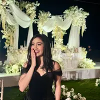 Febby Rastanty tampil mengenakan long dress hitam elegan dengan model bustier lengan off shoulder sheer. Dress model heart neck dipadukan tas Chanel warna senada. [@febbyrastanty]