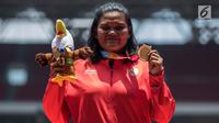 Atlet tolak peluru Indonesia, Suparniyati menunjukkan medali emas Asian Para Games 2018 di SUGBK, Jakarta, Senin (8/10). Suparniyati mencatat tolakan sejauh 10,75 meter. (Bola.com/Vitalis Yogi Trisna)