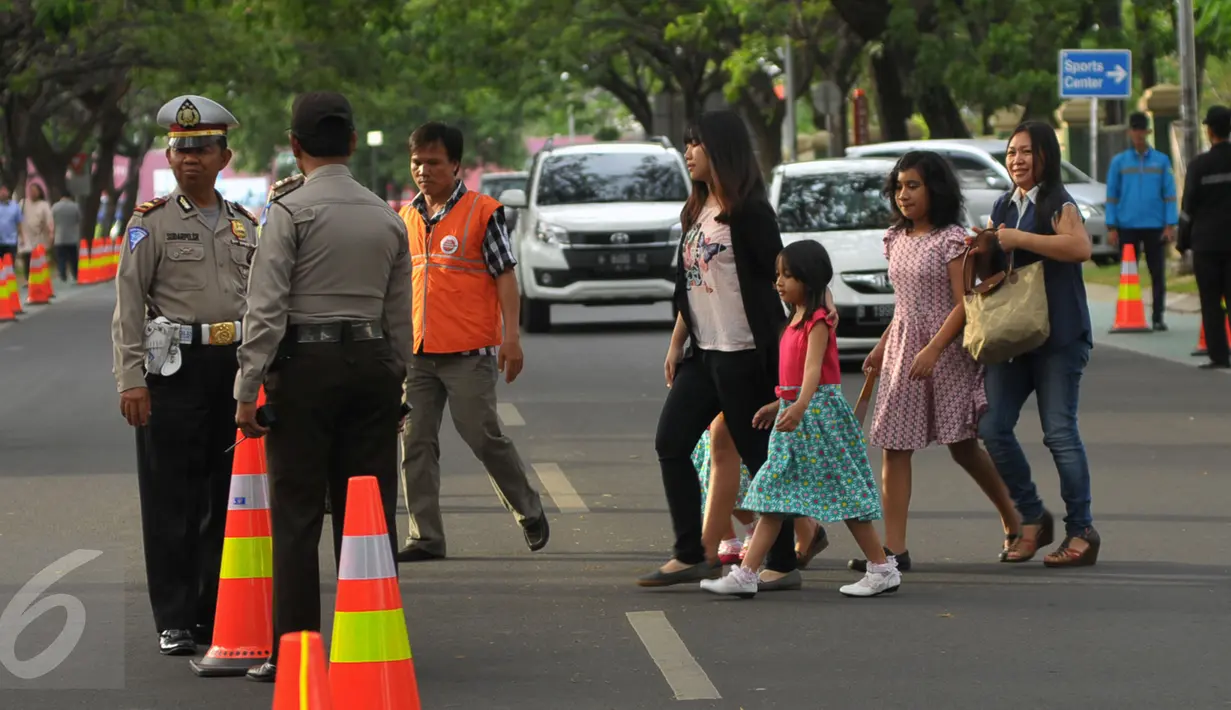Petugas polisi saat berjaga di jalan sekitar Gereja Santo Laurensius, Alam Sutra, Tangerang, Kamis (24/12). Anggota kepolisian dan TNI berjaga disekitaran gereja untuk menanggulangi hal - hal yang tidak diinginkan. (Liputan6.com/Faisal R Syam)