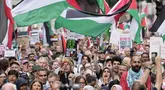 Para pendukung pro-Palestina memegang plakat dan mengibarkan bendera di Downing Street di pusat kota London, Inggris pada 19 Juli 2025. (CARLOS JASSO/AFP)
