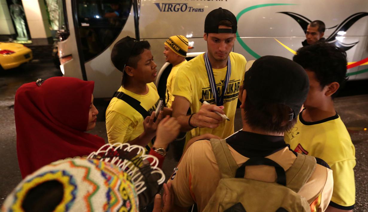 Pemain Mitra Kukar, Patrick Cruz, memberikan tanda tangan ke kaus suporter Mitra Kukar saat tiba di Hotel Sultan, Jakarta, seusai menjuarai Piala Jenderal Sudirman, Minggu (24/1/2016). (Bola.com/Arief Bagus)