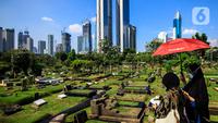 Warga melintas di antara makam di TPU Karet Bivak, Jakarta, Selasa (11/5/2021). Pemprov DKI akan memberlakukan larangan ziarah kubur Idulfitri di seluruh TPU mulai 12 hingga 16 Mei untuk mencegah terjadinya penyebaran Covid-19 saat berkumpul untuk berziarah. (Liputan6.com/JohanTallo)