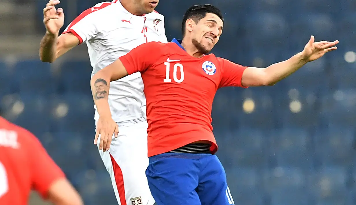 Duel pemain Serbia, Marko Grujic (kiri) dan pemain Chili, Diego Valdes pada laga uji coba di Merkur Arena, Graz, Austria, (4/6/2018). Serbia kalah dari Chili 0-1. (AFP/Joe Klamar)