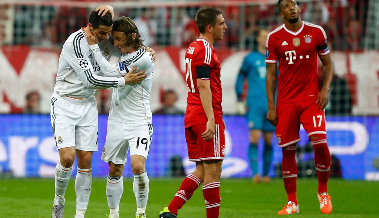 Luka Modric (kedua dari kiri) memeluk Cristiano Ronaldo yang berhasil mencetak gol ketiga Real Madrid di laga laga kedua semifinal Liga Champions kontra Bayern Munich di Allianz Arena, Munich (30/4/2014). (REUTERS/Ralph Orlowski)