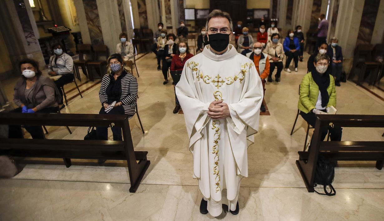 Parson Don Giuseppe Corbari sebelum memulai misa bersama jemaah di SS. Quirico and Giulitta Church di Robbiano, Giussano, Italia, Senin (18/5/2020. Italia secara perlahan melonggarkan kebijakan lockdown akibat pandemi virus corona COVID-19. (AP Photo/Luca Bruno)