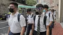 Para siswa sekolah mengenakan topeng dan helm berjalan di luar St. Paul's College selama protes di Hong Kong, Selasa (3/9/2019). Puluhan ribu siswa di Hong Kong mogok sekolah di hari pertama tahun ajaran baru. (AP Photo/Kin Cheung)