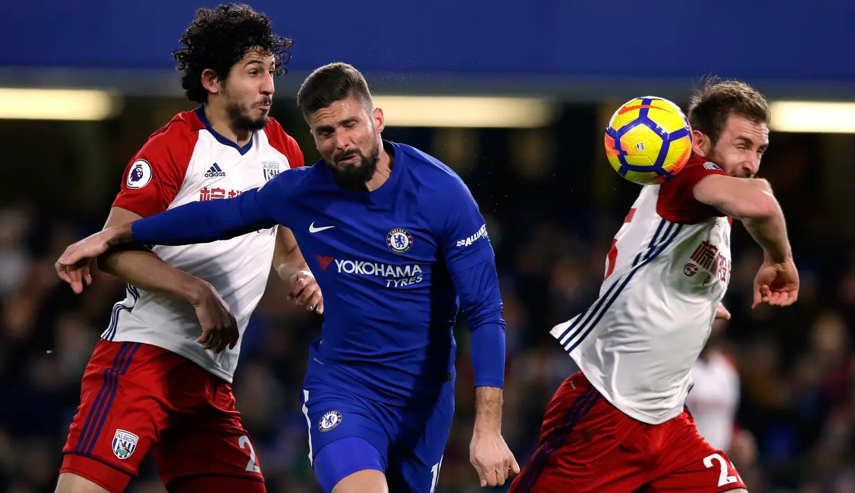 Pemain Chelsea, Oliver Giroud berebut bola dengan pemain West Bromwich Albion, Ahmed Hegazi dan Craig Dawson pada laga pekan ke-27 Premier League di Stamford Bridge, Selasa (13/2). The Blues membenamkan West Bromwich Albion 3-0. (AP/Alastair Grant)