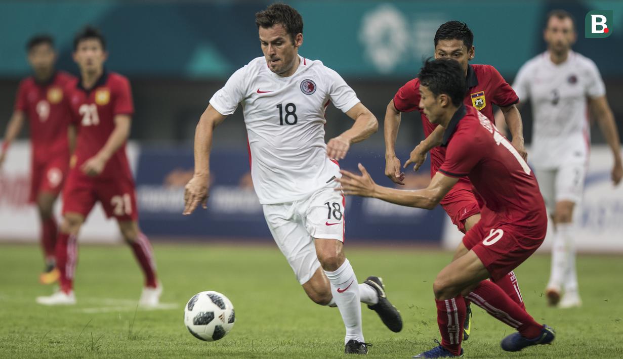 Striker Hongkong, Tarres Jorge, berusaha melewati gelandang Laos, Lounlasy Lathasy, pada laga Grup A Asian Games di Stadion Patriot, Jawa Barat, Jumat (10/8/2018). Hongkong menang 3-1 atas Laos. (Bola.com/Vitalis Yogi Trisna)