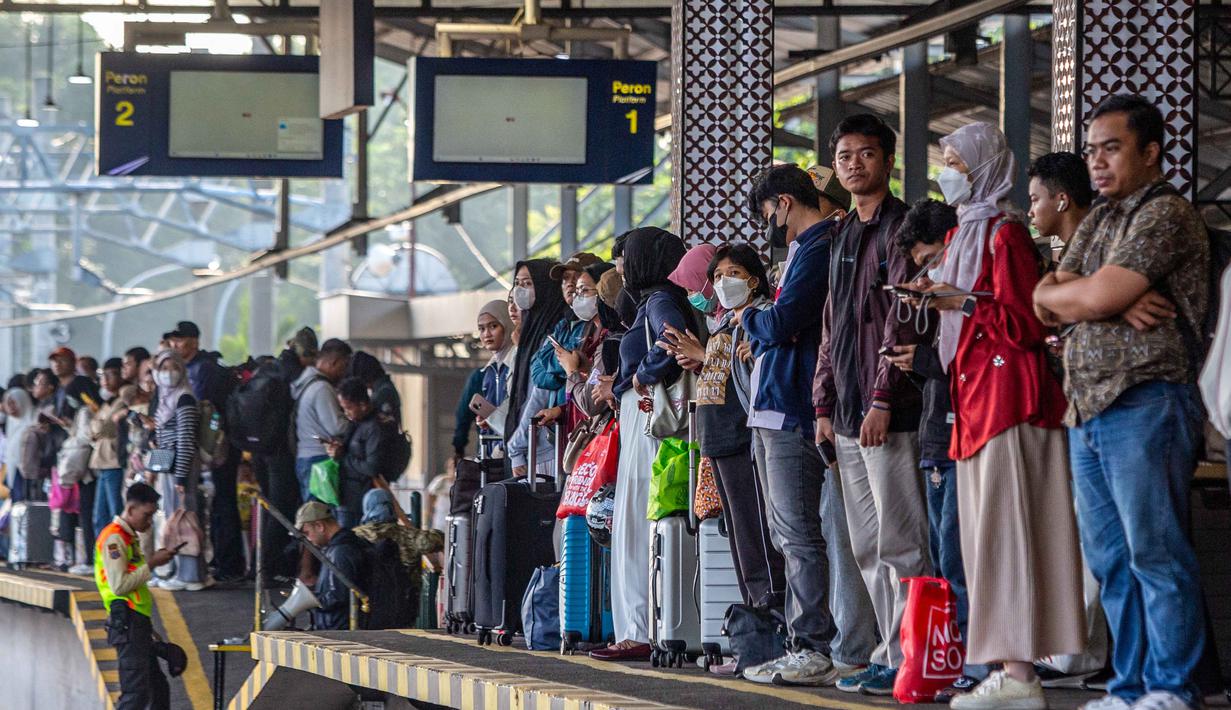 Stasiun tersebut dipadati ribuan penumpang kereta api jarak jauh, baik yang baru tiba maupun yang akan berangkat menuju berbagai daerah tujuan. Tampak dalam foto, orang-orang menunggu kereta api di stasiun kereta api Lempuyangan, Yogyakarta pada 14 Maret 2026. (DEVI RAHMAN/AFP)