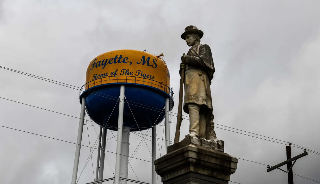 Patung yang memberi penghormatan ke tentara Konfederasi yang tewas pada Perang Sipil masih berdiri di pengadilan Fayette, Jefferson County, Mississippi (28/9/2020). Sisa-sisa perkebunan kapas yang berdiri di sana adalah bangunan rapuh yang tersembunyi di antara tumbuhan lebat. (AFP/Chandan Khanna)