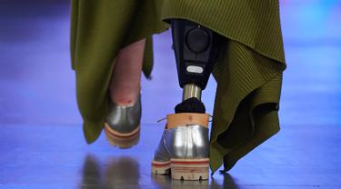 Sebuah kaki palsu yang dikenakan seorang model saat menampilkan koleksi Spring/Summer 2018 Teatum Jones pada hari pertama London Fashion Week, 15 September 2017. Model tersebut memakai gaun panjang warna hijau lumut dan kaki palsu. (NIKLAS HALLE'N/AFP)