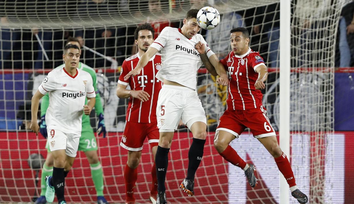 Duel pemain Sevilla, Clement Lenglet (kiri) dan pemain Bayern, Thiago pada leg pertama Liga Champions di Sanchez Pizjuan stadium, Seville, (3/4/2018) waktu setempat. Beyern menang 2-1. (AP/Miguel Morenatti)