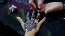 Tradisi ini merupakan simbol kegembiraan dalam menyambut Hari Raya Idul Fitri setelah sebulan berpuasa. Tampak dalam foto, seorang ahli kecantikan melukis 'Henna' tradisional di tangan pelanggan untuk perayaan Idul Fitri, yang menandai berakhirnya bulan suci Ramadan, di Rawalpindi, Pakistan, Rabu, 18 Maret 2026. (AP Photo/Anjum Naveed)