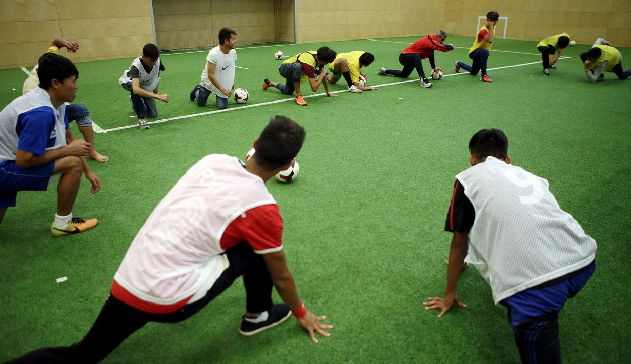 Para pencari suaka melakukan pemanasan saat mengikuti latihan bersama klub FK Austria Wien di Wina, Austria. (Reuters/Heinz-Peter Bader)