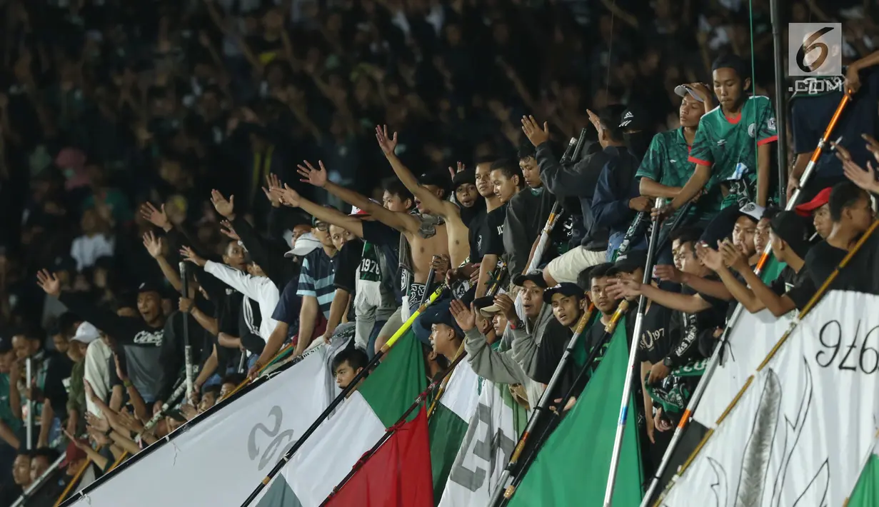Suporter tim Elang Jawa bersorak saat menyaksikan laga uji coba Timnas Indonesia u-19 melawan PSS Sleman di Stadion Maguwohardjo, Sleman, Sabtu (12/8). Laga berakhir imbang 2-2. (Liputan6.com/Helmi Fithriansyah)