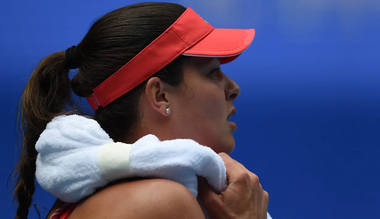 Ana Ivanovic mengerikan keringat dengan handuk saat bertanding melawan petenis Australia Tammi Patterson pada hari kedua Australia Open 2016 di Melbourne (19/1/2016). (AFP PHOTO/GREG WOOD)