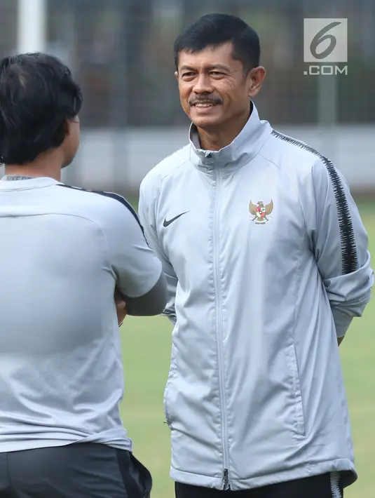 Pelatih Timnas Indonesia U-19, Indra Sjafri (kanan) berbincang dengan timnya saat latihan di Lapangan A Kompleks GBK Jakarta, Selasa (23/10). Latihan ini persiapan melawan UEA di penyisihan Grup A Piala AFC U-19 2018. (Liputan6.com/Helmi Fithriansyah)