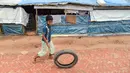 Seorang anak pengungsi Rohingya bermain dengan ban bekas di Kamp Pengungsian Kutupalong, Ukhia, Bangladesh, Jumat (13/9/2019). Kamp ini adalah salah satu dari dua kamp pengungsian yang dikelola pemerintah di Cox's Bazar. (MUNIR UZ ZAMAN/AFP)