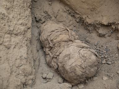 Sebuah mumi terlihat di situs arkeologi Cajamarquilla, di mana enam mumi anak-anak ditemukan di Cajamarquilla, dekat Lima, Peru pada 13 Februari 2022. Menurut para arkeolog, mumi tersebut berusia antara 800 hingga 1.200 tahun. (Guadalupe Pardo / AFP)