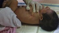 Perawat saat mempraktekan cara memandikan bayi kepada seorang ibu di RSIA Tambak, Jakarta, Kamis (18/02/2021). Melatih para ibu baru untuk memandikan bayi pertama tersebut dilakukan dengan menerapkan protokol kesehatan ketat. (Liputan6.com/Herman Zakharia)