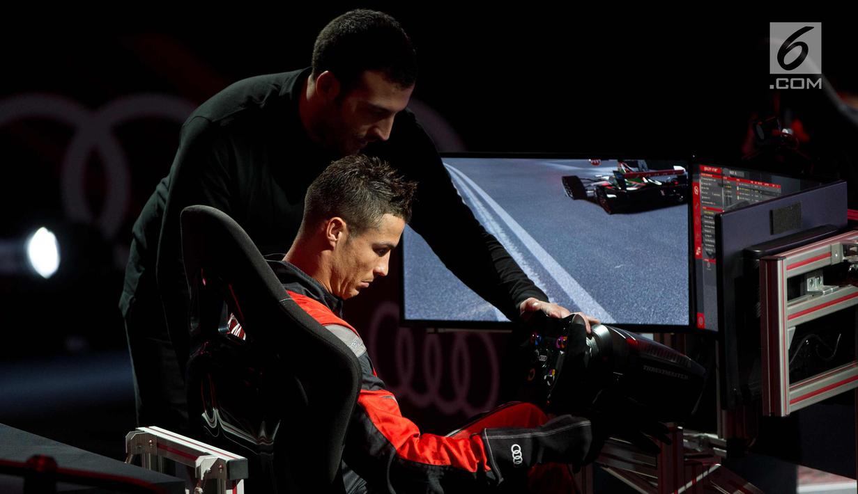 Penyerang Real Madrid, Cristiano Ronaldo bersiap untuk balapan di simulator Formula E selama sebuah acara promosi di Madrid, Spanyol, (23/11). (AP Photo / Paul White)