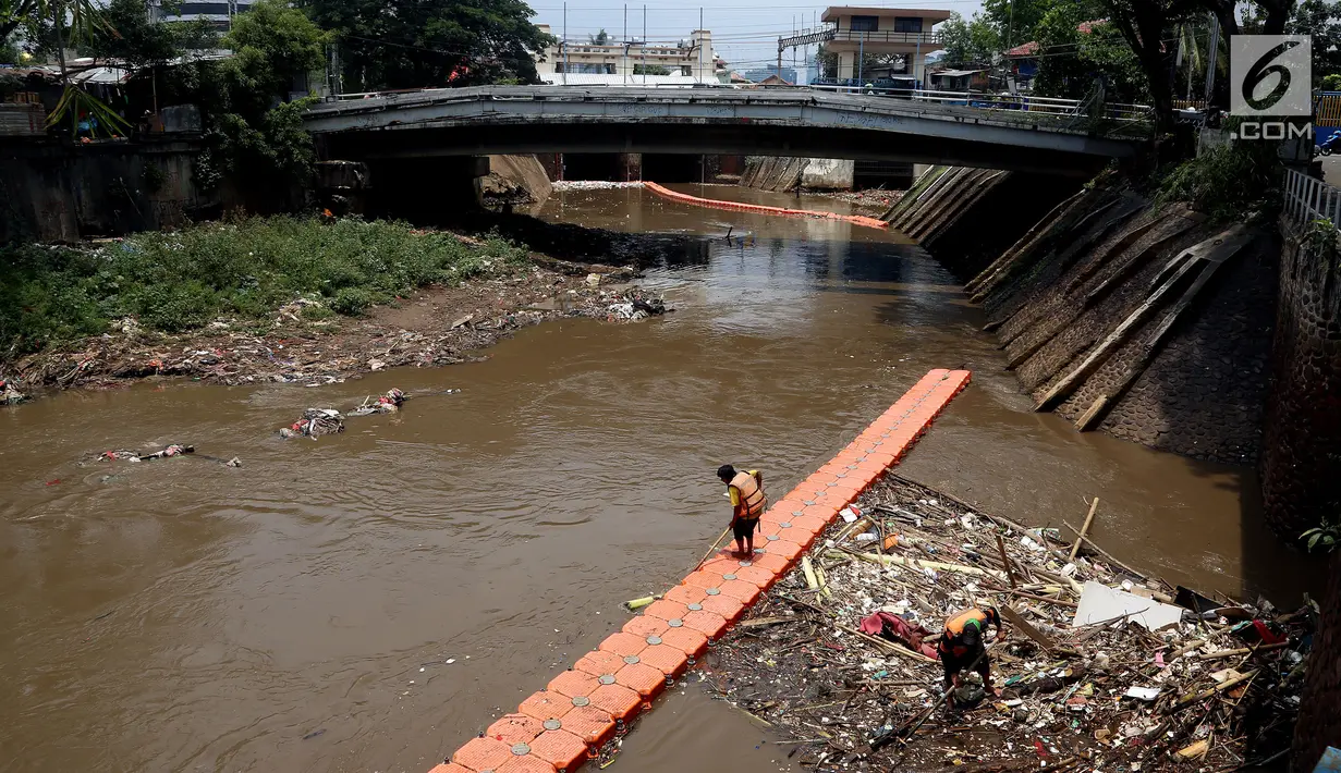 Petugas kebersihan Pemprov DKI mencoba mengurai sampah di Pintu air Manggarai, Jakarta, Senin (2/10). Dinas Kebersihan DKI mengangkat sampah seberat 90-220 ton/hari dari badan air di sungai, waduk, setu dan danau di Ibu Kota. (Liputan6.com/Johan Tallo)
