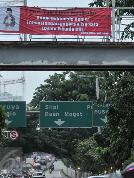 Kendaraan melintas di bawah spanduk Yusril Ihza Mahendra yang menolak penggunaan isu SARA dalam Pilkada DKI di Jalan Panjang, Jakarta, Rabu (2/11). Jelang Pilkada DKI 2017, spanduk imbauan tepis isu SARA mulai bertebaran. (Liputan6.com/Yoppy Renato)