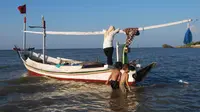 sejumlah anak sedang bermain di dekat perahu Madura di perkampungan nelayan Desa Tanjung Bumi, Kabupaten Bangkalan. (Liputan6.com/Musthofa Aldo)