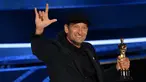 Aktor AS Troy Kotsur menerima penghargaan di atas panggung Academy Award ke-94 di Dolby Theatre di Hollywood, California, Minggu (27/3/2022). Troy Kotsur memenangkan piala Oscar dalam kategori pendukung terbaik untuk perannya sebagai seorang nelayan dan ayah dalam film CODA. (Robyn Beck/AFP)