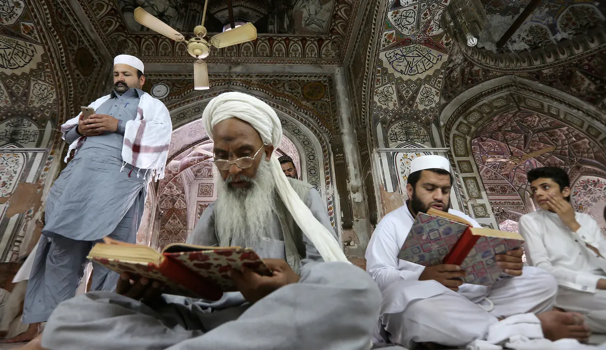 Sejumlah orang membaca AlQuran saat Ramadan hari pertama di Peshawar, Pakistan, Sabtu (27/5). Beragam ibadah dilakukan umat muslim untuk berlomba-lomba mencari pahala saat Ramadan. (AP Photo / Muhammad Sajjad)