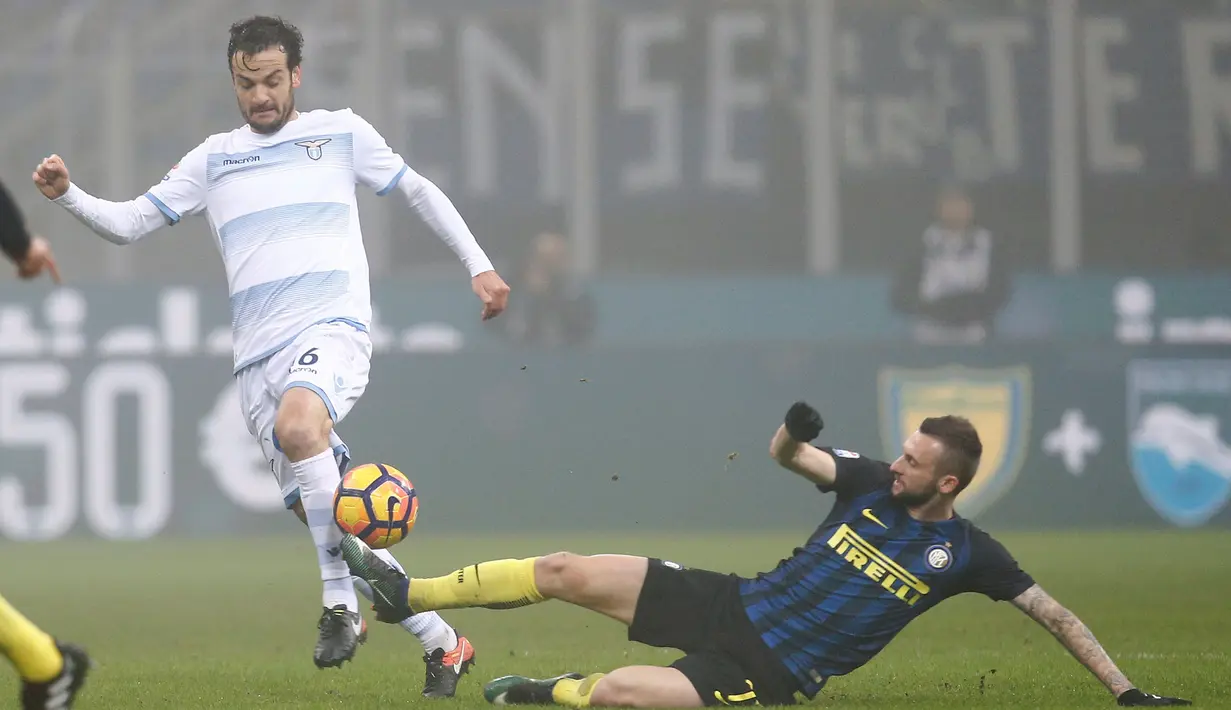 Gelandang Lazio, Marco Parolo berusaha melewati gelandang Inter Milan, Marcelo Brozović pada lanjutan liga Italia Serie A di Stadion San Siro, Milan, (22/12). Inter Menang atas Lazio dengan skor 3-0. (REUTERS/Alessandro Garofalo)