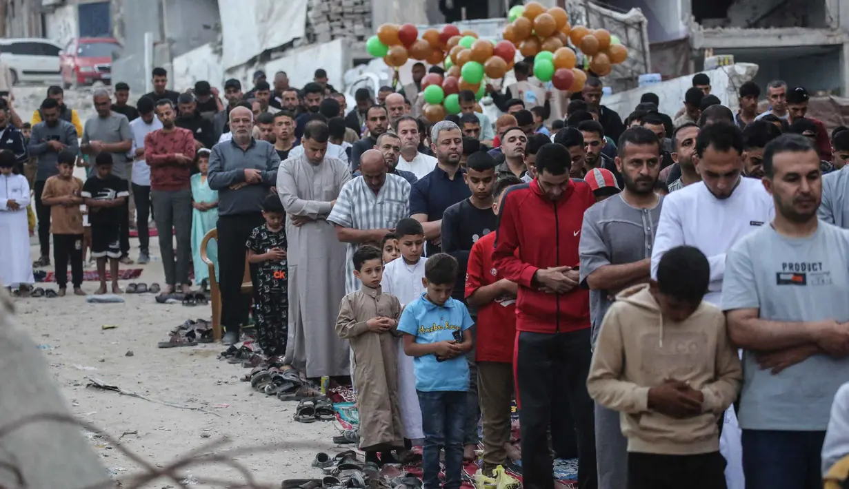 Warga Palestina melaksanakan salat menandai dimulainya Idul Adha, Hari Raya Kurban, di jalan yang rusak parah di Khan Yunis, Jalur Gaza Selatan, pada Rabu 27 Mei 2026. (BASHAR TALEB/AFP)