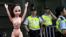 Pengunjuk rasa membawa boneka di luar markas polisi di kawasan Wan Chai, Hong Kong, Minggu (2/8). Demo tersebut merupakan aksi simpati terhadap seorang perempuan yang di penjara karena dituduh menyerang polisi menggunakan payudaranya. (REUTERS/Tyrone Siu)