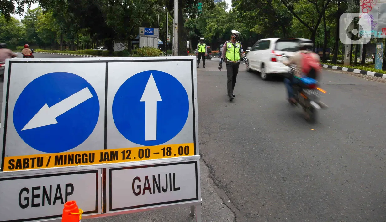 Sejumlah petugas mengatur lalu lintas saat uji coba ganjil-genap di Jalan Margonda Raya, Depok, Jawa Barat, Minggu (5/12/2021). Polres Metro Kota Depok bersama Dishub menyiapkan enam pos pemeriksaan dalam melaksanakan uji coba penerapan ganjil-genap (gage). (Liputan6.com/Herman Zakharia)