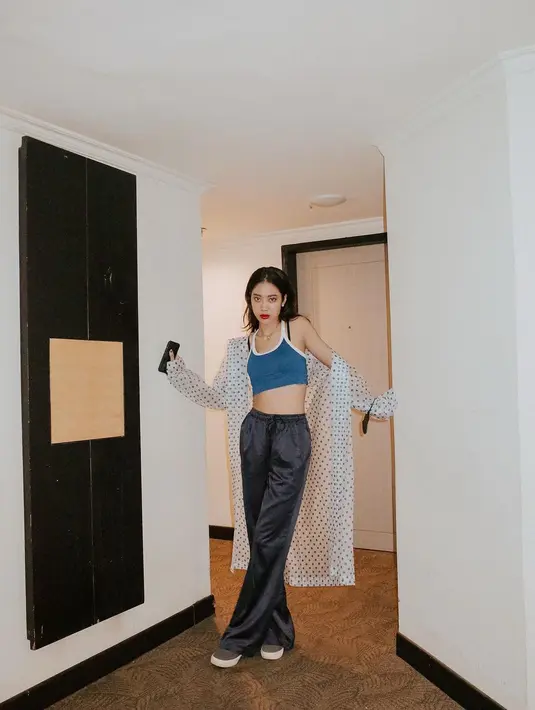 Tampil santai, Widi Vierratale memilih mengenakan crop top berwarna biru. Dipadukan dengan celana satin dan outer polkadot yang unik. [instagram/widikidiwdkdw]