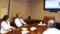 Bersama penasihat senior kepresidenan, Valerie Jarrett (kiri), orang nomor satu di Amerika Serikat, Barrack Obama menyaksikan laga Sam's Army melawan Der Panzer di atas pesawat Air Force One, (26//6/2014). (REUTERS/Larry Downing)