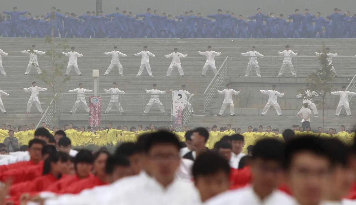 Ribuan orang melakukan pertunjukan bela diri Taichi di salah satu lapangan sekolah di Provinsi Henan, Cina, Minggu (18/10/2015). Pertunjukan ini diselenggarakan di 15 lokasi yang berbeda. (REUTERS/Stringer)