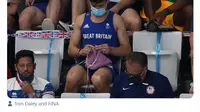 Atlet loncah indah, Tom Daley, tertangkap kamera tengah merajut saat menyaksikan final loncat indah 3 meter putri di Olimpiade Tokyo 2020.