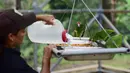 Ahli biologi Iris Rodriguez memberi makan burung beo Puerto Rico di pusat penangkaran di Iguaca Aviary, El Yunque, Puerto Rico, (6/11). Departemen Sumber Daya Alam Puerto Rico berupaya menyelamatkan populasi beo Puerto Rico. (AP Photo/Carlos Giusti)