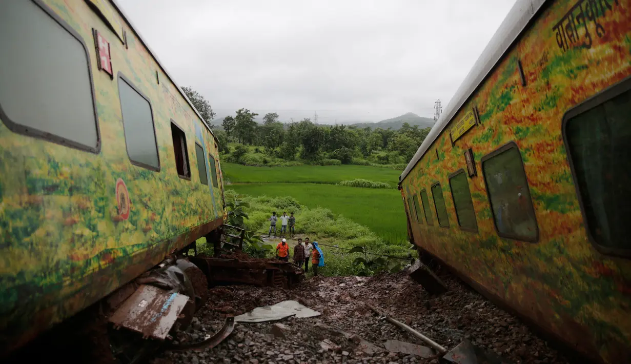Warga setempat melihat dua gerbon kereta yang tergelincir di Asangaon, India (29/8). (AP Photo / Rafiq Maqbool)