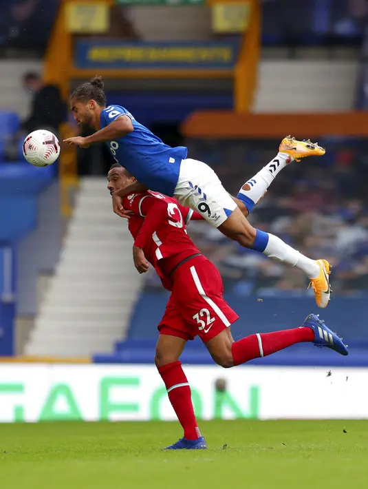 Pemain Everton Dominic Calvert-Lewin (atas) berebut bola dengan pemain Liverpool Joel Matip pada pertandingan Liga Premier Inggris di Stadion Goodison Park, Liverpool, Inggris, Sabtu (17/10/2020). Pertandingan berakhir dengan skor 2-2. (Cath Ivill/Pool via AP)