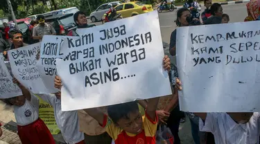 Sejumlah anak-anak berseragam sekolah beserta orangtuanya berdemo di depan Balai Kota, Jakarta, (22/9/14). (Liputan6.com/Faizal Fanani)
